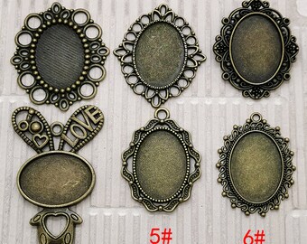 May include: Six different styles of antique gold-toned metal pendant trays with oval-shaped glass inserts. The trays are decorated with intricate designs and are numbered 1 through 6.