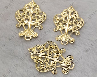 May include: Three gold-colored filigree embellishments with an ornate, symmetrical design. Each piece features a central vertical element with swirling details and a fan-shaped base. The openwork design allows light to pass through.