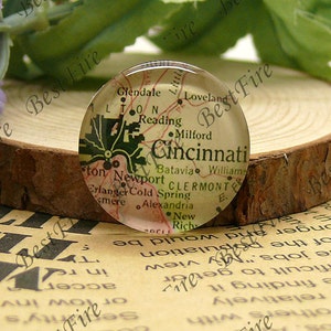 Puede incluir: Un cabujón de vidrio con un mapa vintage de Cincinnati, Ohio. El mapa muestra las principales calles y puntos de referencia de la ciudad, incluido el río Ohio, el zoológico de Cincinnati y la Universidad de Cincinnati.