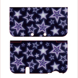 Op de afbeelding: Een tweedelige skin voor een handheld gameconsole, met een herhalend patroon van paarse en witte sterren op een donkerblauwe achtergrond. De skin is ontworpen om op de boven- en onderkant van het apparaat te passen.