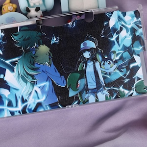 May include: A clear phone case featuring a vibrant anime-style illustration with characters in shades of blue, green, and white. The design includes dynamic lightning effects and detailed character art. Additional decorative items are visible in the background.