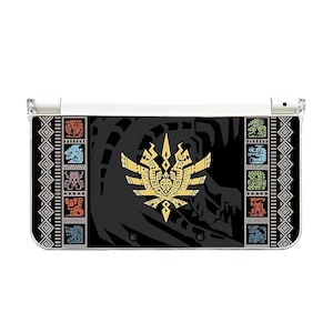 May include: A black and white Nintendo 3DS case featuring a gold emblem and various colorful icons. The case has a white hinge and a clear plastic top. The design is symmetrical with geometric patterns on the sides.