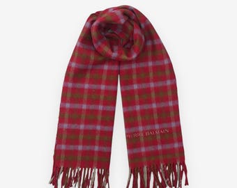 May include: A red plaid scarf with a fringed edge. The scarf features a pattern of red, green, and light purple squares. The words "PIERRE BALMAIN" are printed on the scarf.