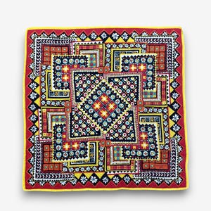 Può includere: Un foulard quadrato in seta con un vivace motivo geometrico di quadrati annidati in rosso, giallo, blu e nero. Il design include intricati motivi floreali, piccoli cerchi e forme a stella. La parola Ungaro è stampata nell'angolo.