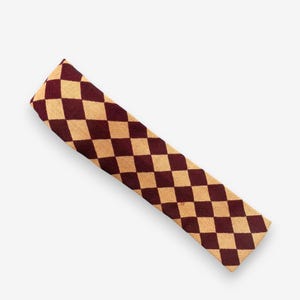 Könnte beinhalten: Ein langes, rechteckiges Stoffstück mit einem sich wiederholenden Muster aus weinroten und beigefarbenen Rauten. Der Artikel ist wahrscheinlich eine Krawatte oder ein Schal mit einem klassischen, geometrischen Design. Der Stoff scheint gewebt zu sein.