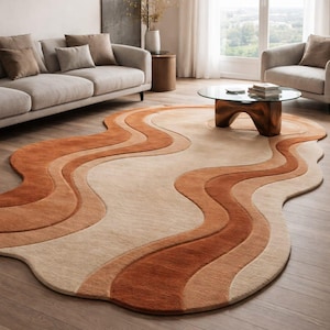 Könnte beinhalten: Moderner Teppich mit wellenförmigem, abstraktem Design in Beige-, Hellbraun- und Rostorangetönen. Das Design zeigt fließende, organische Formen. Der Teppich liegt auf einem Holzboden und verleiht dem Raum Wärme. Maße: ca. 200cm x 300cm.