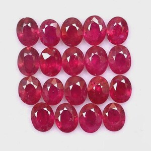 May include: Eighteen oval-shaped rubies, each with a deep red colour. The gemstones are arranged in a grid pattern against a white background, highlighting their polished facets and vibrant colour.