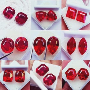 Puede incluir: Una colección de gemas rojas vibrantes en varias formas, incluyendo cuadradas, ovaladas y en forma de pera. Cada gema se muestra en un estuche blanco, mostrando sus brillantes facetas y su rico color. Las gemas son probablemente rubíes.