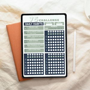 May include: A digital tablet displaying a "75 Challenge" checklist. The screen features sections for daily habits, including diet, workouts, water intake, reading, progress pictures, and steps. A stylus and an orange notebook are next to the tablet.