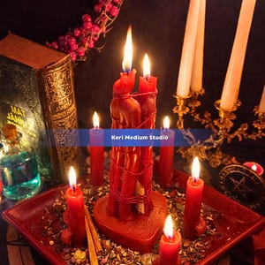 May include: A collection of lit red candles, including a large central candle formation, sit on a red tray. A vintage book, a small bottle, and a decorative candle holder are also present. The image has a mystical or spiritual theme.
