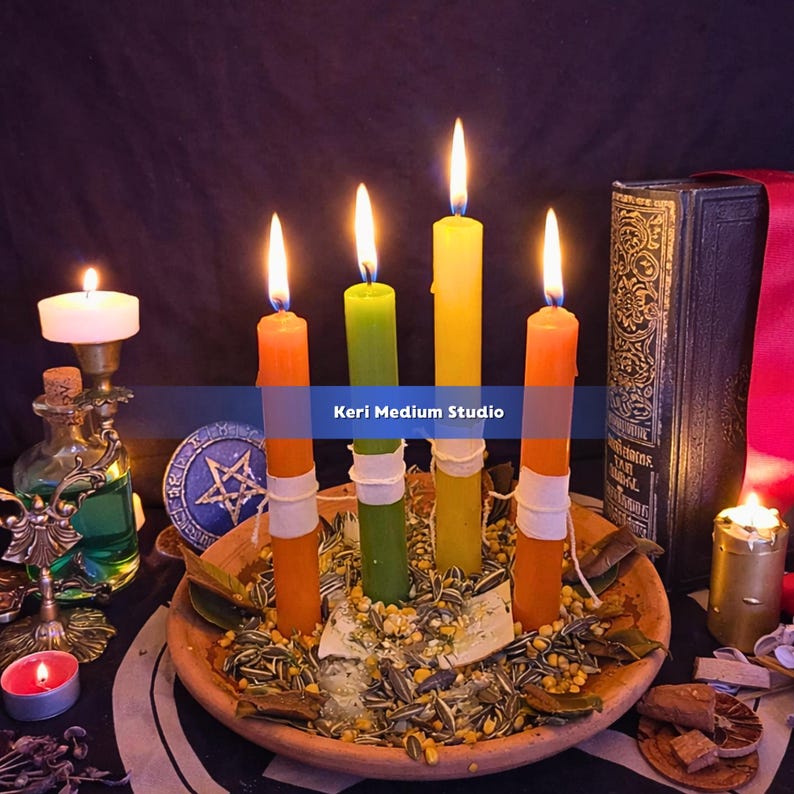 May include: A still-life image featuring lit candles in orange, green, and yellow hues, arranged in a wooden bowl with seeds and herbs. A vintage book and other candles are in the background. The text "Keri Medium Studio" is visible.
