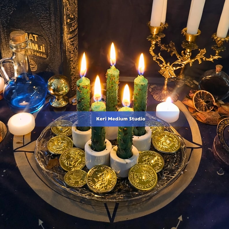 May include: A mystical scene featuring five green candles in white holders, surrounded by gold coins on a glass plate. A candelabra and a bottle of blue liquid are in the background. The candles are lit, creating a warm, inviting glow.