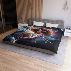May include: A black blanket featuring a vibrant space-themed design. The artwork depicts a cosmic scene with planets, spacecraft, and a large, purple octopus-like creature. The blanket has the word "SPACE" in green.