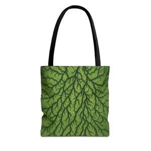 May include: Green tote bag with a detailed, leaf-like pattern. The bag has a black handle and a vibrant, nature-inspired design. The bag's design is a close-up of a green leaf.