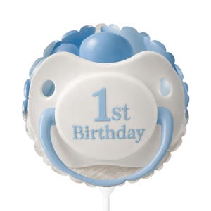 May include: A round, light blue and white balloon shaped like a dummy. The centre features a white circular area with the blue text 1st Birthday printed on it. The balloon has a light blue ring and a white stick at the bottom for holding.