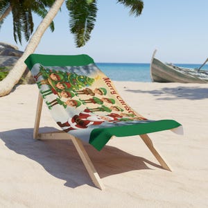 Pode incluir: Cadeira de praia de madeira com um design de Natal verde e branco. O design apresenta o Papai Noel, elfos e uma árvore de Natal decorada. As palavras "Merry Christmas" são impressas na cadeira.