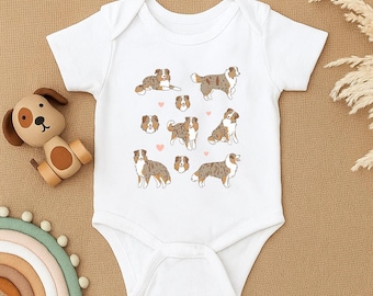 Könnte beinhalten: Weißer Baby-Body mit einem sich wiederholenden Muster von illustrierten Australian Shepherds in verschiedenen Posen, mit kleinen rosa Herzen. Die Hunde sind in Braun-, Weiß- und Grautönen dargestellt.