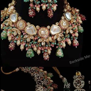 May include: An ornate gold-toned necklace and earring set. The jewelry features large, clear, and colorful gemstones, pearls, and intricate floral designs. The set includes a necklace and matching earrings, perfect for special occasions.