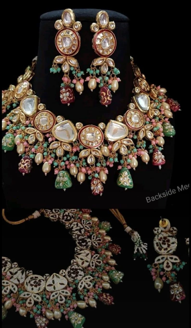 May include: An ornate gold-toned necklace and earring set. The jewelry features large, clear, and colorful gemstones, pearls, and intricate floral designs. The set includes a necklace and matching earrings, perfect for special occasions.