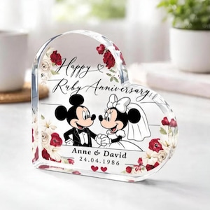 May include: A heart-shaped clear acrylic plaque featuring a printed illustration of Mickey and Minnie Mouse in wedding attire. The text reads Happy Ruby Anniversary, Anne & David, and 24.04.1986, surrounded by red and white floral accents.