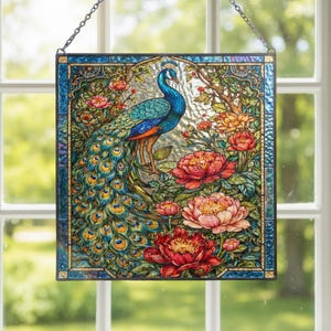 Könnte beinhalten: Buntglas-Fensterbild mit einem Pfau mit blauen und türkisfarbenen Federn, umgeben von Pfingstrosen und Grün. Das quadratische Panel hat einen dekorativen blauen Rahmen und wird von einer Kette gehalten. Größe: ca. 30 cm x 30 cm.