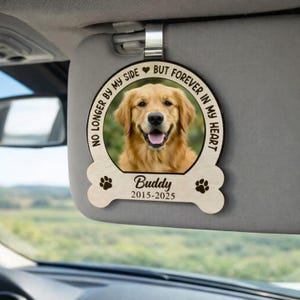 Peut inclure: Accessoire de voiture en bois avec une photo d'un golden retriever. L'ornement en forme d'os porte le nom du chien, "Buddy", et les années "2015-2025". Le texte autour de la photo dit "Plus près de moi, mais toujours dans mon cœur."