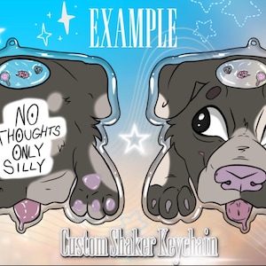May include: Custom shaker keychain featuring a cartoon dog with a gray and white coat. The keychain has the text "NO THOUGHTS ONLY SILLY" and a clear border. The dog has a pink tongue and nose.