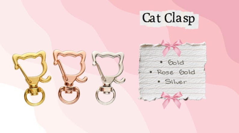 May include: Three cat-shaped clasps in gold, rose gold, and silver. The clasps have a swivel base and a ring for attaching to items. Text on a paper reads "Cat Clasp" and lists the colors: Gold, Rose Gold, and Silver.