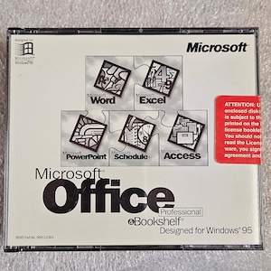 May include: A Microsoft Office Professional software package for Windows 95. The cover features the Microsoft logo and the names of the included applications: Word, Excel, PowerPoint, Schedule+, and Access. A red sticker with text is on the right.