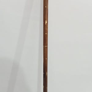 Peut inclure: Canne de marche d&eacute;corative avec une poign&eacute;e et des accents dor&eacute;s. Le f&ucirc;t est en bois brun fonc&eacute; avec des d&eacute;tails incrust&eacute;s dor&eacute;s. La canne mesure environ 91 cm de long.