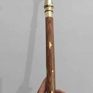 Peut inclure: Canne de marche d&eacute;corative avec une poign&eacute;e et des accents dor&eacute;s. La tige est en bois avec des incrustations dor&eacute;es en forme de feuilles. La poign&eacute;e a un design textur&eacute;. La canne mesure environ 91 cm de long.