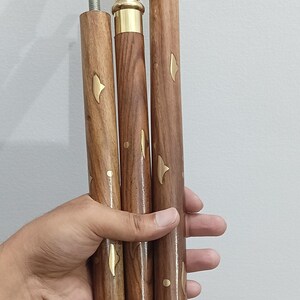 Peut inclure: Canne de marche d&eacute;corative avec une poign&eacute;e en laiton et un f&ucirc;t en bois. La poign&eacute;e pr&eacute;sente un motif orn&eacute; et textur&eacute;. Le f&ucirc;t en bois est marron avec des accents dor&eacute;s. La canne est con&ccedil;ue pour le soutien et le style.
