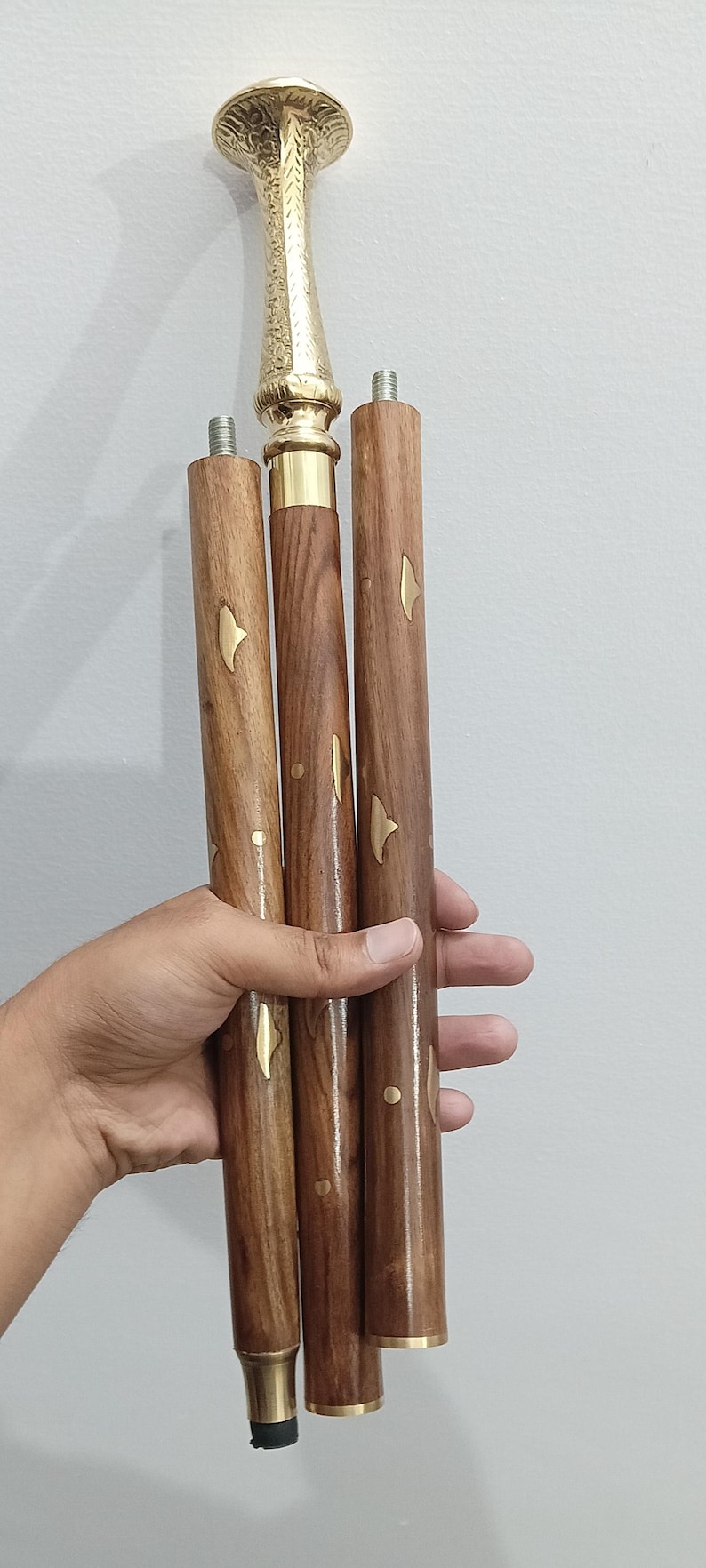 Peut inclure: Canne de marche d&eacute;corative avec une poign&eacute;e en laiton et un f&ucirc;t en bois. La poign&eacute;e pr&eacute;sente un motif orn&eacute; et textur&eacute;. Le f&ucirc;t en bois est marron avec des accents dor&eacute;s. La canne est con&ccedil;ue pour le soutien et le style.
