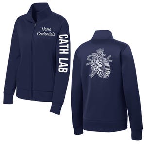 May include: Navy blue zip-up jacket with white text. The front features "Name Credentials" and "CATH LAB" on the sleeve. The back displays a heart-shaped design made of medical terms. A practical and stylish garment.