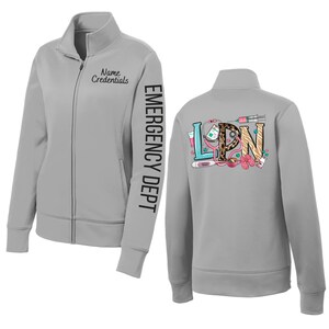May include: A light gray zip-up jacket with the text "Name Credentials" and "EMERGENCY DEPT" printed on the sleeve. The back of the jacket features the letters "LPN" with medical-themed graphics, including a stethoscope and syringe.