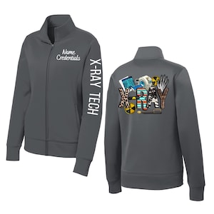 May include: A dark gray zip-up jacket with the text "Name Credentials" and "X-RAY TECH" in white. The back of the jacket features a colorful design with the word "X-RAY" and medical-themed graphics. The jacket has a full zipper and two front pockets.