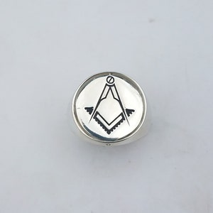 K&ouml;nnte beinhalten: Ein silberner Ring mit einem schwarz-wei&szlig;en freimaurerischen Symbol, das auf der Oberseite graviert ist.