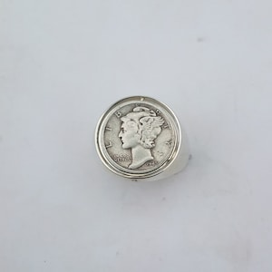 K&ouml;nnte beinhalten: Silberring mit einer 1945 Walking Liberty-Halbdollar-M&uuml;nze. Die M&uuml;nze ist in einer Zargenfassung gefasst und der Ring ist poliert.