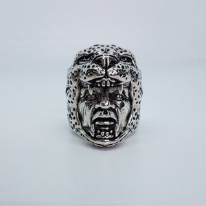 May include: A silver ring with a detailed design of a snarling jaguar head.