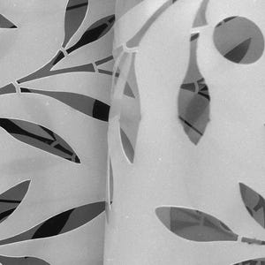 May include: A light-colored, flexible sheet featuring a repeating laser-cut pattern of elongated leaves and stems. The surface is smooth and semi-translucent. The text FLEXIBLE Y DURADERA is printed in white on the lower portion of the sheet.