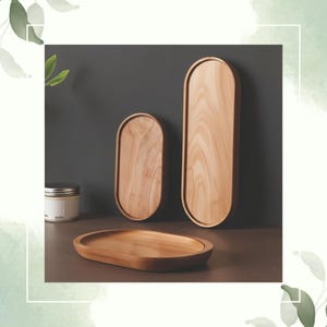 May include: Three wooden trays in varying sizes. The trays are oval-shaped with a light wood grain finish. One tray is flat, while the other two have raised edges. The background is a neutral gray.