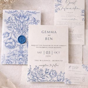 May include: Wedding invitation suite with blue floral designs on a cream background. The invitation includes the names "Gemma and Ben", the date "03 OCT 2026", and the venue "The Wildings - Morpeth". Includes RSVP and guest information cards.