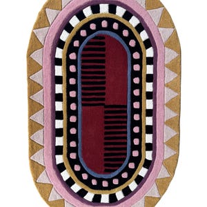 K&ouml;nnte beinhalten: Ovaler Teppich mit geometrischem Muster in Rosa, Gold, Schwarz, Wei&szlig; und Burgunderrot. Das Design umfasst Dreiecke, Streifen und gepunktete Linien, was einen modernen und k&uuml;nstlerischen Look erzeugt. Geeignet f&uuml;r Wohn- oder Schlafzimmer.