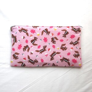 May include: A pink zippered pouch with a repeating pattern of brown squirrels, pink leaves, and yellow acorns.