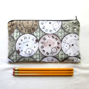 May include: A zippered pouch with a fabric design of multiple vintage clock faces in shades of brown, white, and grey. The clock faces have Roman numeral markings and some have the words "Waltham" and "South Bend" printed on them.