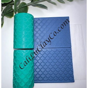 May include: Two teal cylindrical clay tools and two blue rectangular clay tools with a mermaid scale pattern. The text "CaliLuClayCo.com" is visible on the tools. The text "Larger Pattern" is also visible.