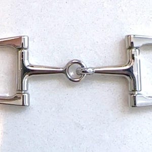May include: A shiny, silver D-ring horse bit. The bit features a central ring connecting two D-shaped rings. The metal is highly polished, indicating a well-cared-for piece of equestrian equipment.