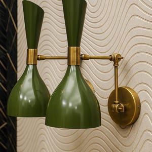 Op de afbeelding: Een paar olijfgroene wandlampen met messing accenten. De lampen hebben een conische kap en een cilindrische bovenkant. De lampen zijn gemonteerd op een getextureerde, crèmekleurige muur. Het ontwerp is modern.