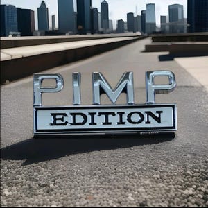 May include: Chrome "PIMP EDITION" emblem. The silver emblem with black lettering is set against a textured grey surface. A blurred cityscape forms the background.
