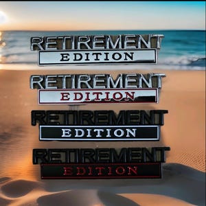 May include: Four metal car emblems with the text "RETIREMENT EDITION". The emblems are in silver, black, and red, with varying colour combinations for the text and background. The background is a beach scene.